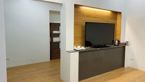 A modern kitchen with a built-in TV, wooden accents, and a coffee station.