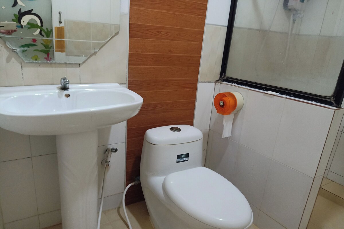 A bathroom with a white sink, toilet, and shower area.