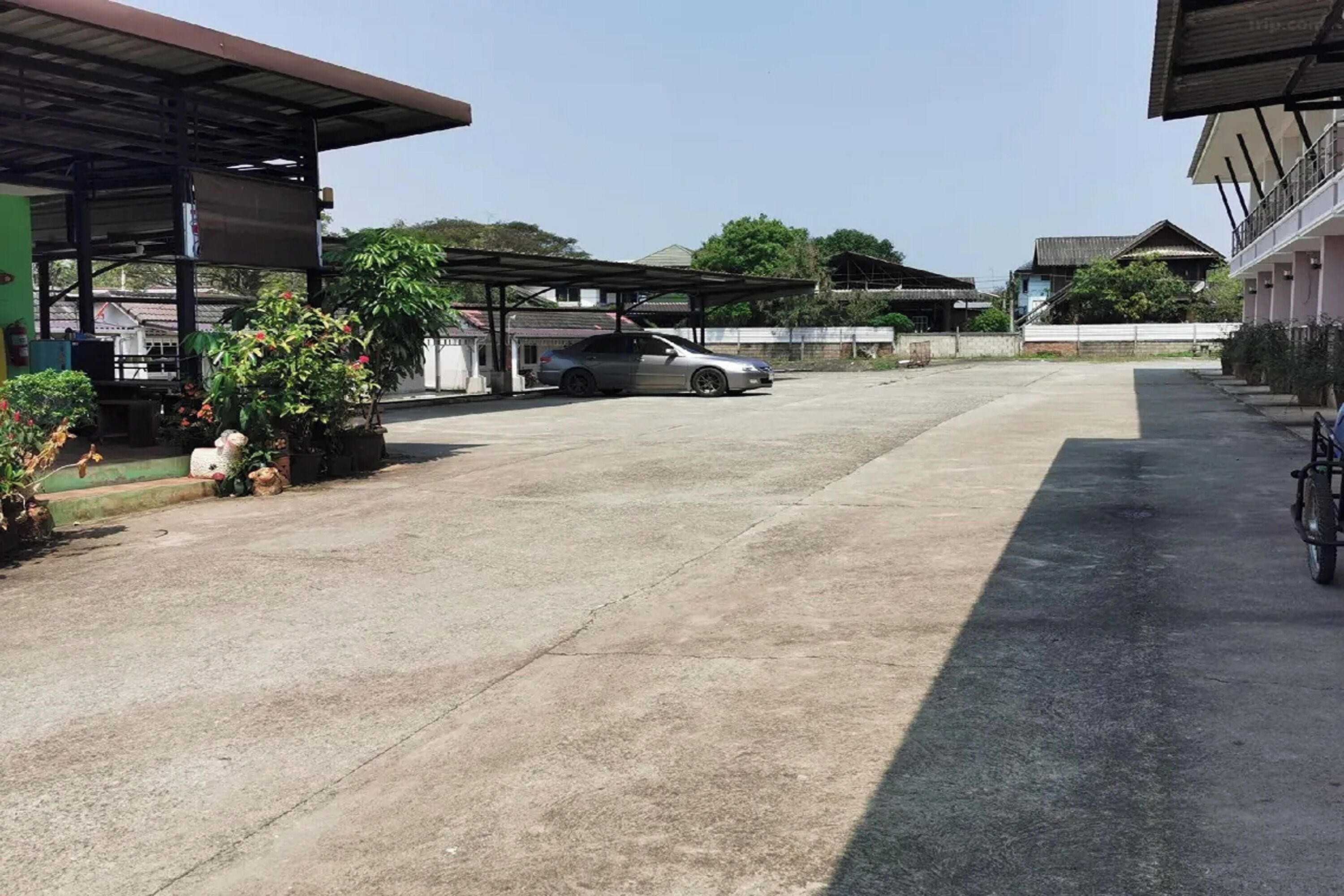 A parking area with a covered car and a bicycle.