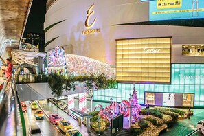 Un centro comercial con una gran estructura iluminada, una tienda Cartier y una tienda Tiffany & Co.