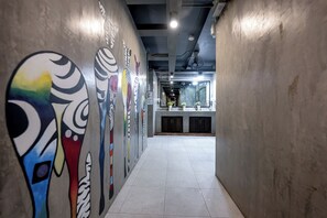 Un pasillo con arte murales coloridos y una cocina al fondo.