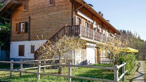 Une cabane en rondins avec un balcon, une clôture en bois et un ciel dégagé.