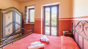 A bedroom with a bed, a dresser, a window, and a balcony view. - Apartment in Marche near Urbino and Pool (Apecchio)