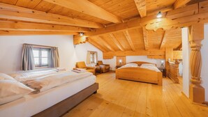 A wooden-paneled room with two beds, a sofa, and a desk. - Chalet in Kitzbühel near Ski Lifts (Kitzbühel)