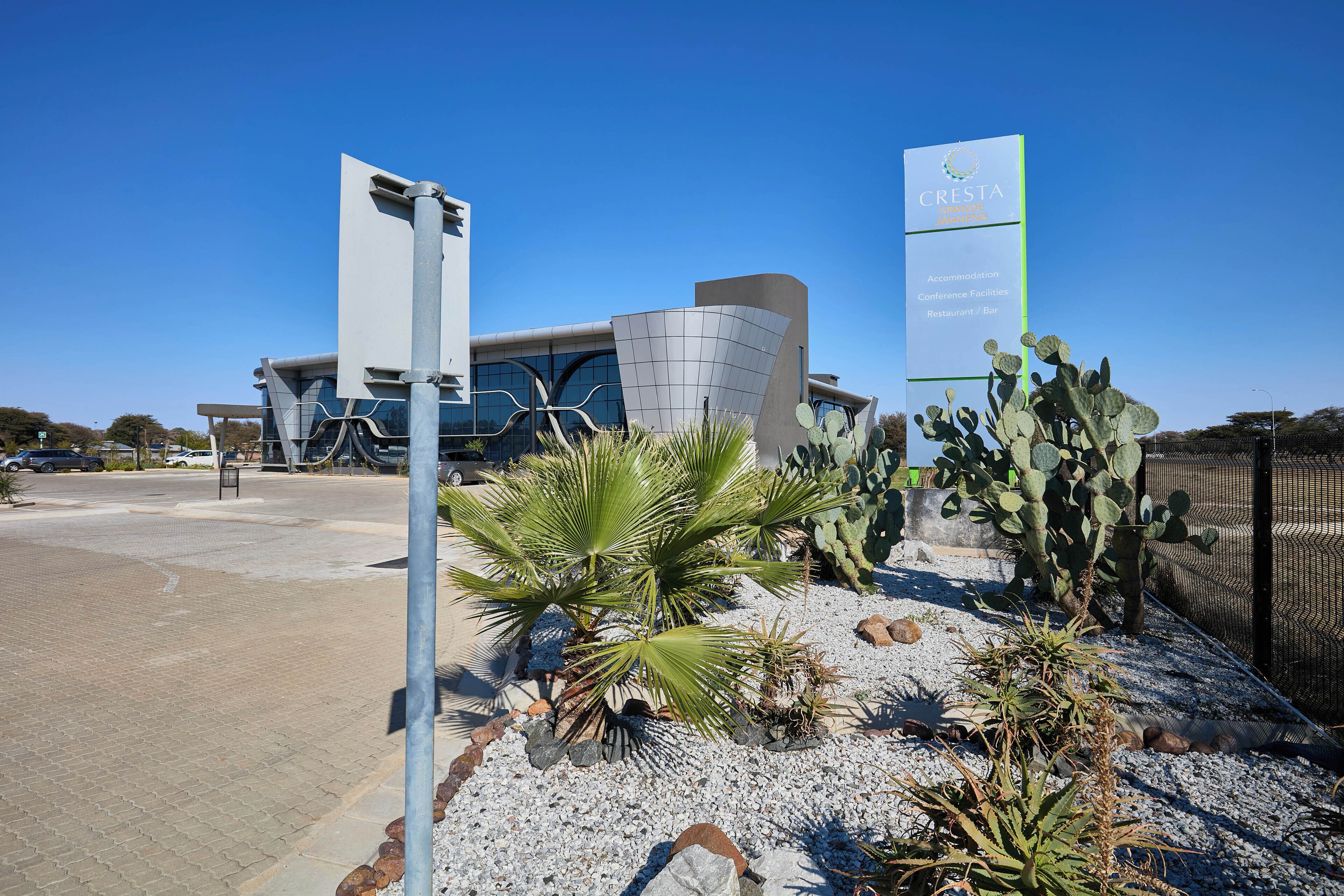 A modern building with a sign for CRESTA Hotel & Conference Facilities.