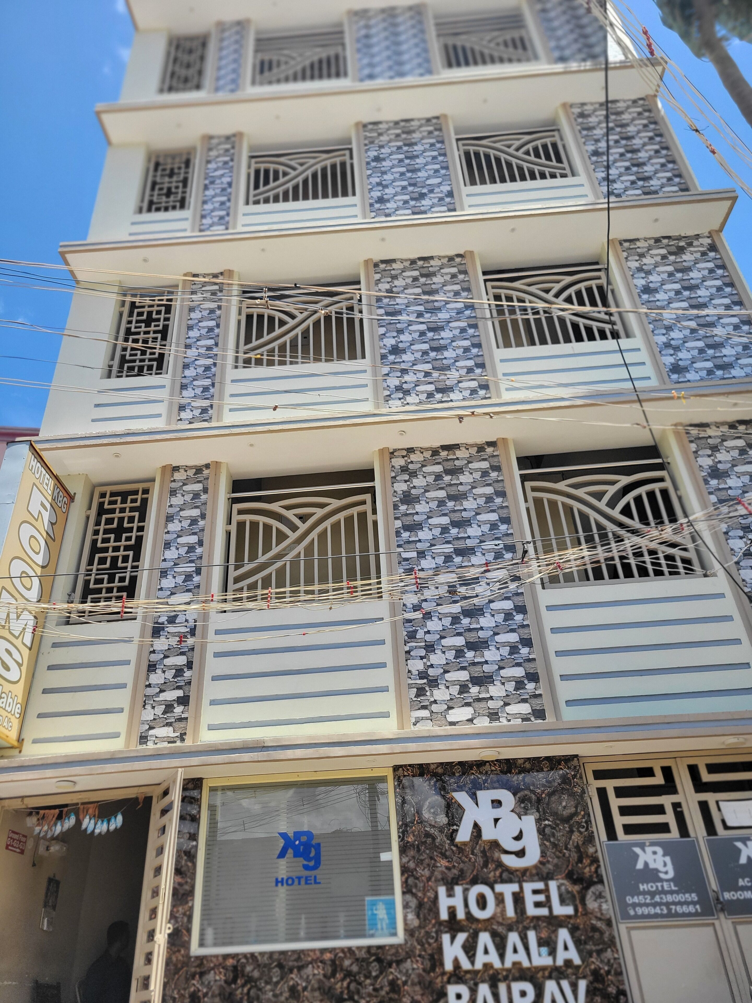 A multi-story hotel with balconies, a sign for 'HOTEL KAALA PARIVAR', and a visible room number.