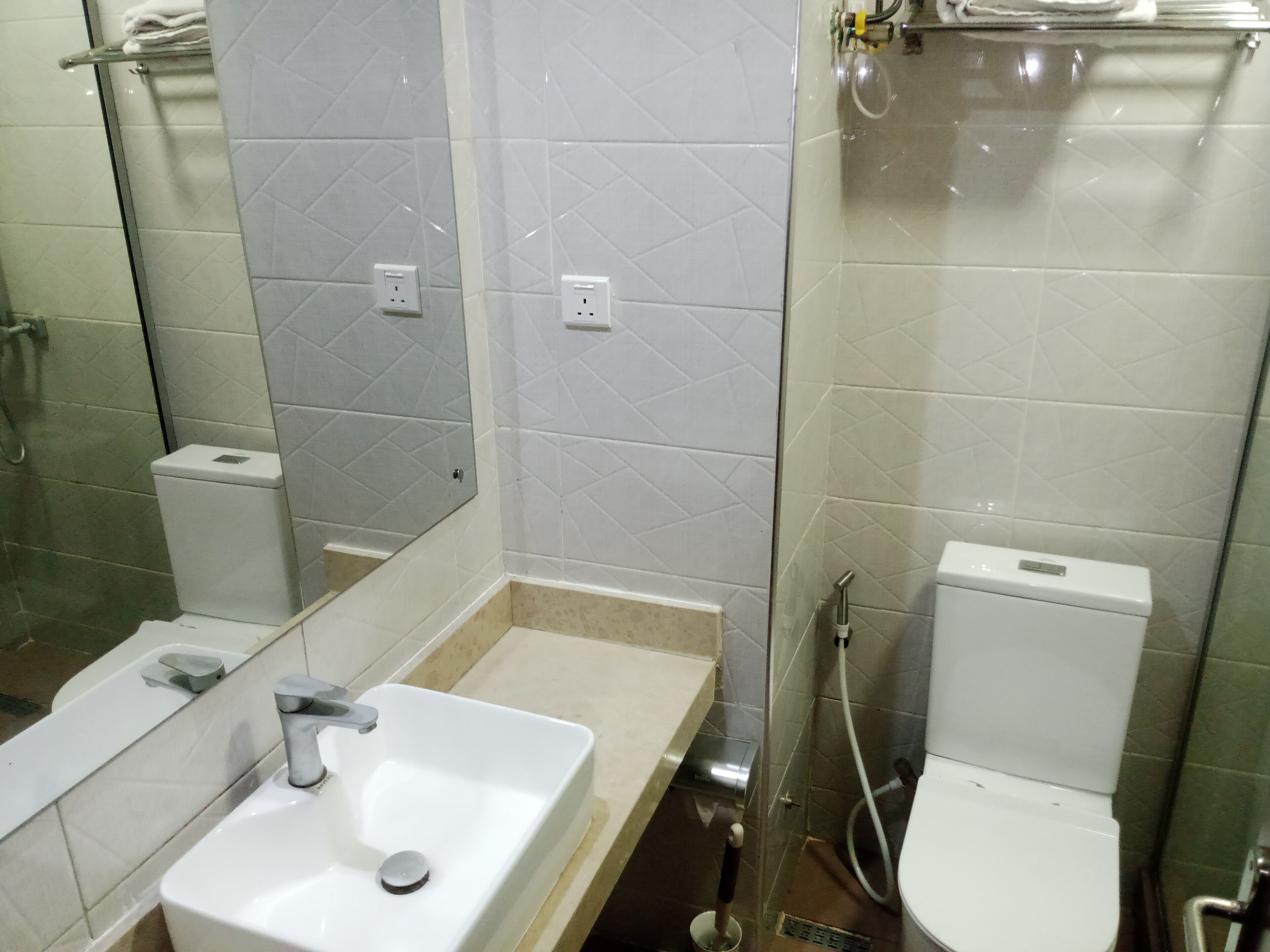 A bathroom with a white sink, a toilet, and a shower area.