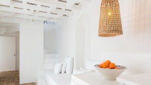 A modern, white-themed bedroom with a bed, white walls, and a wicker pendant light. - Casa boutique Encalada  (Vejer de la Frontera)