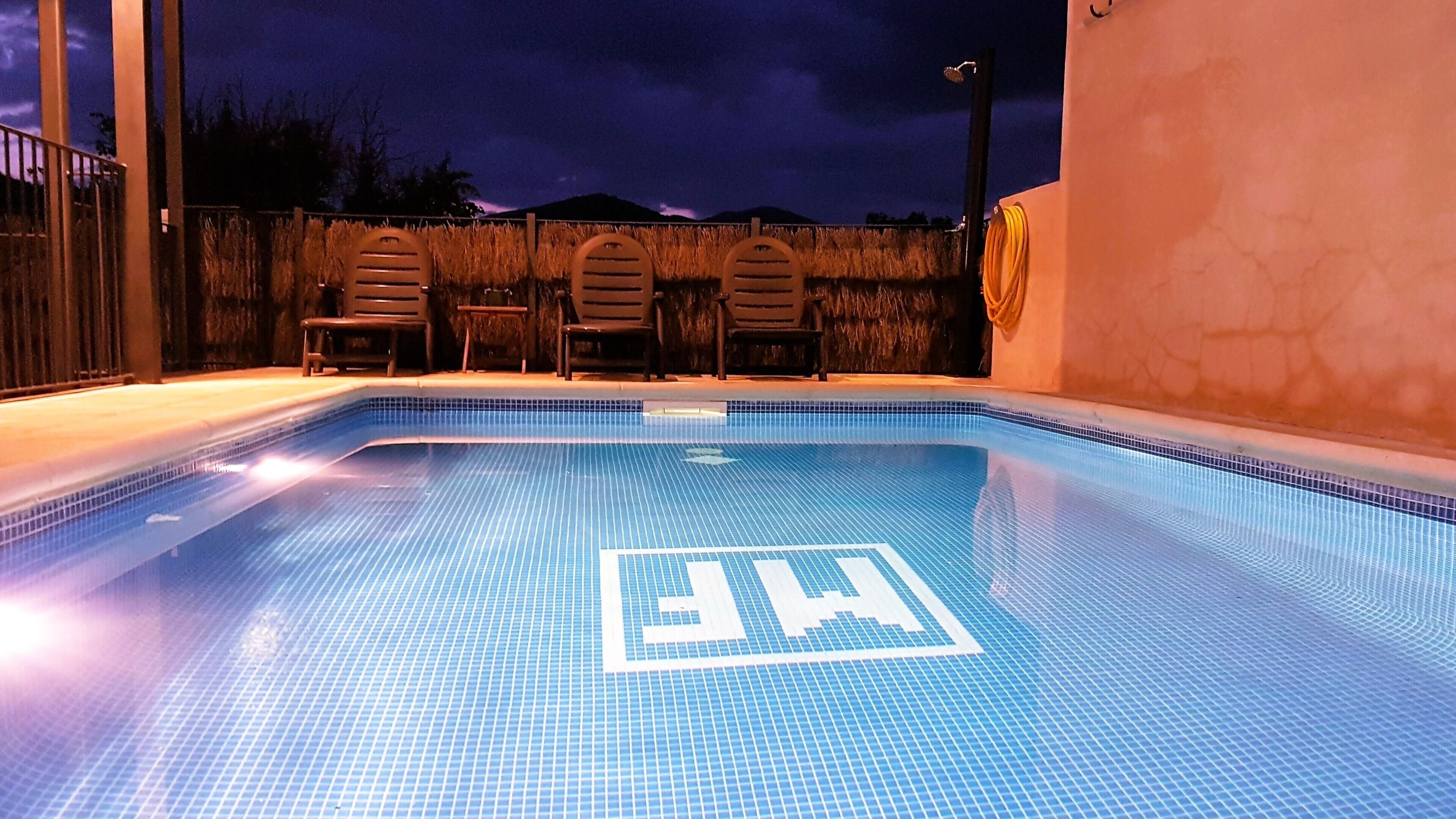 An indoor swimming pool with a tiled floor and a logo in the center.