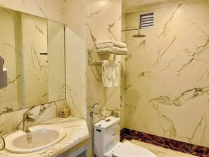 A bathroom with a marble sink, a toilet, and a shower. - Gold Hotel Luxury (Tu Son)