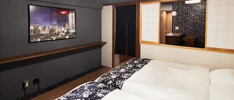 Habitación de hotel moderna con vista a la ciudad, una cama grande con ropa de cama floral, un estante de madera y una partición tradicional al estilo japonés.
