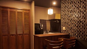 Una cocina con armarios de madera, una cafetera y un salpicadero de azulejos.