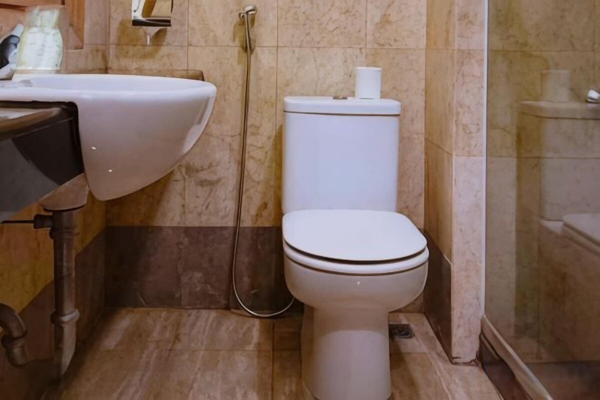A bathroom with a toilet, sink, and shower.