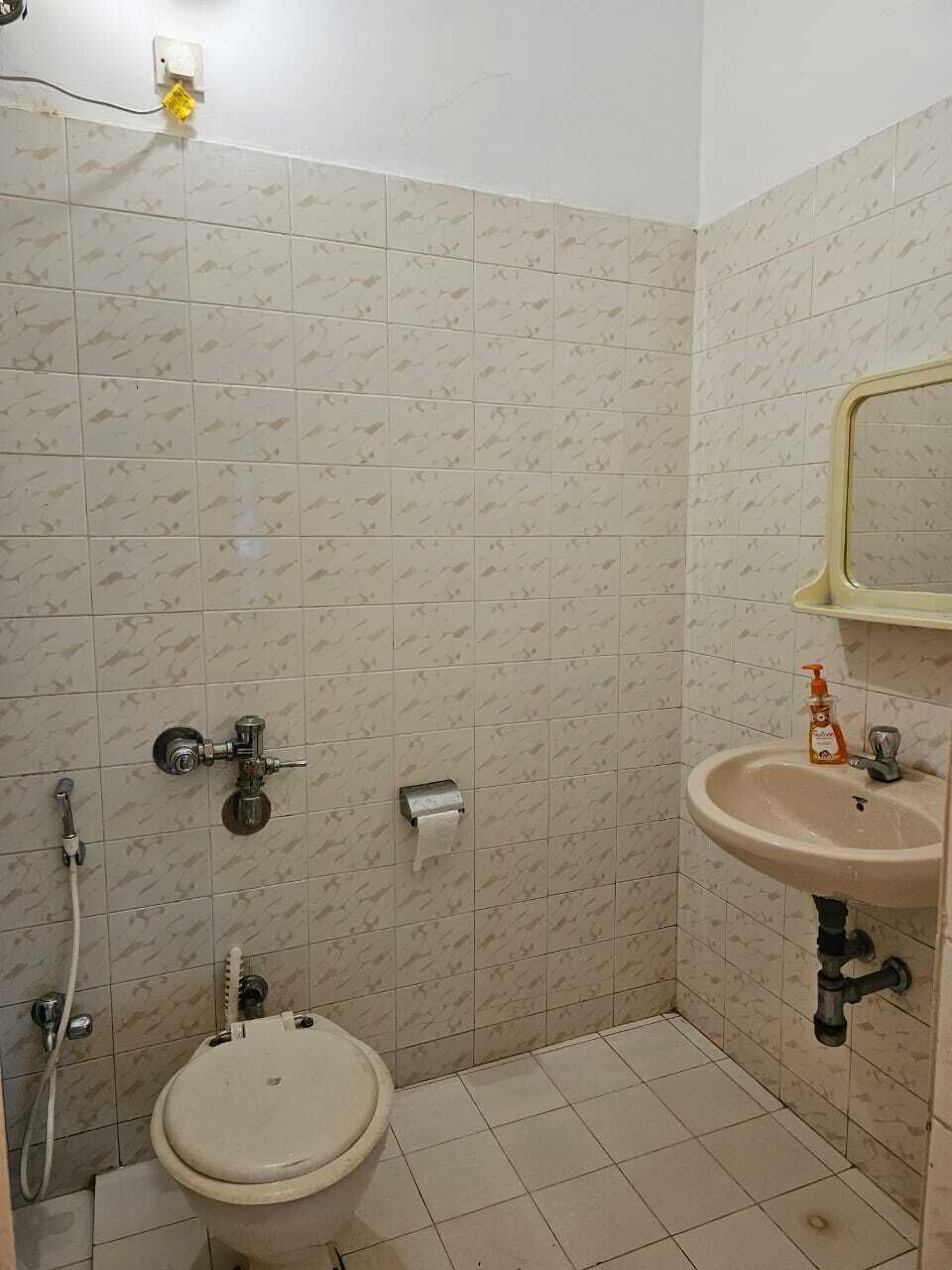 Un baño pequeño con inodoro, lavamanos y ducha.