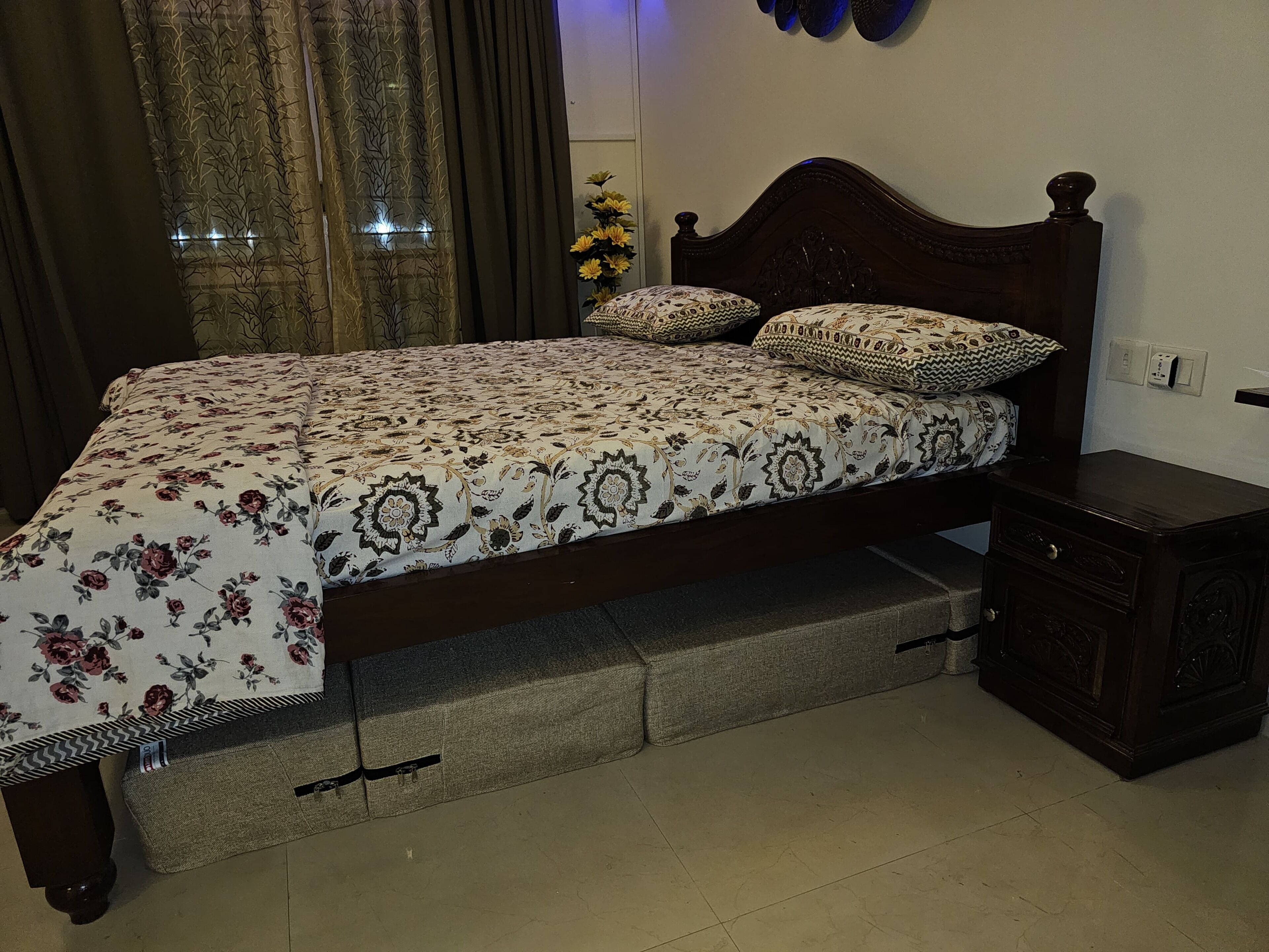Un dormitorio con cama, mesita de noche, cómoda y ventana con cortinas.