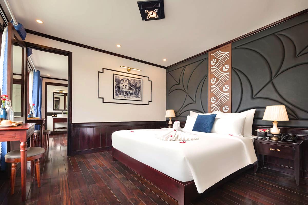 Una habitación de hotel con una cama grande, un escritorio y un espejo.