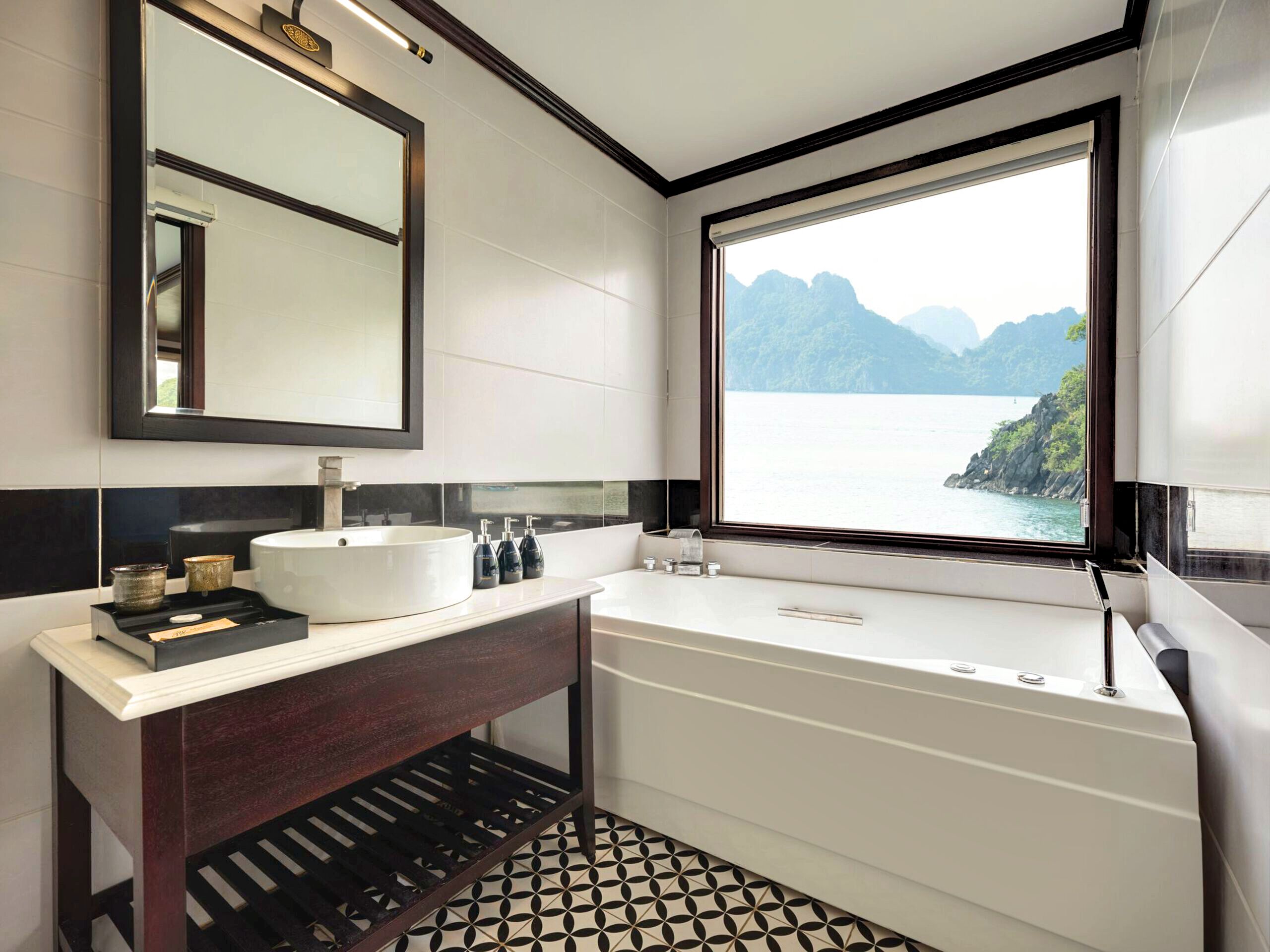 A modern bathroom with a large window, a round sink, and a wooden vanity.