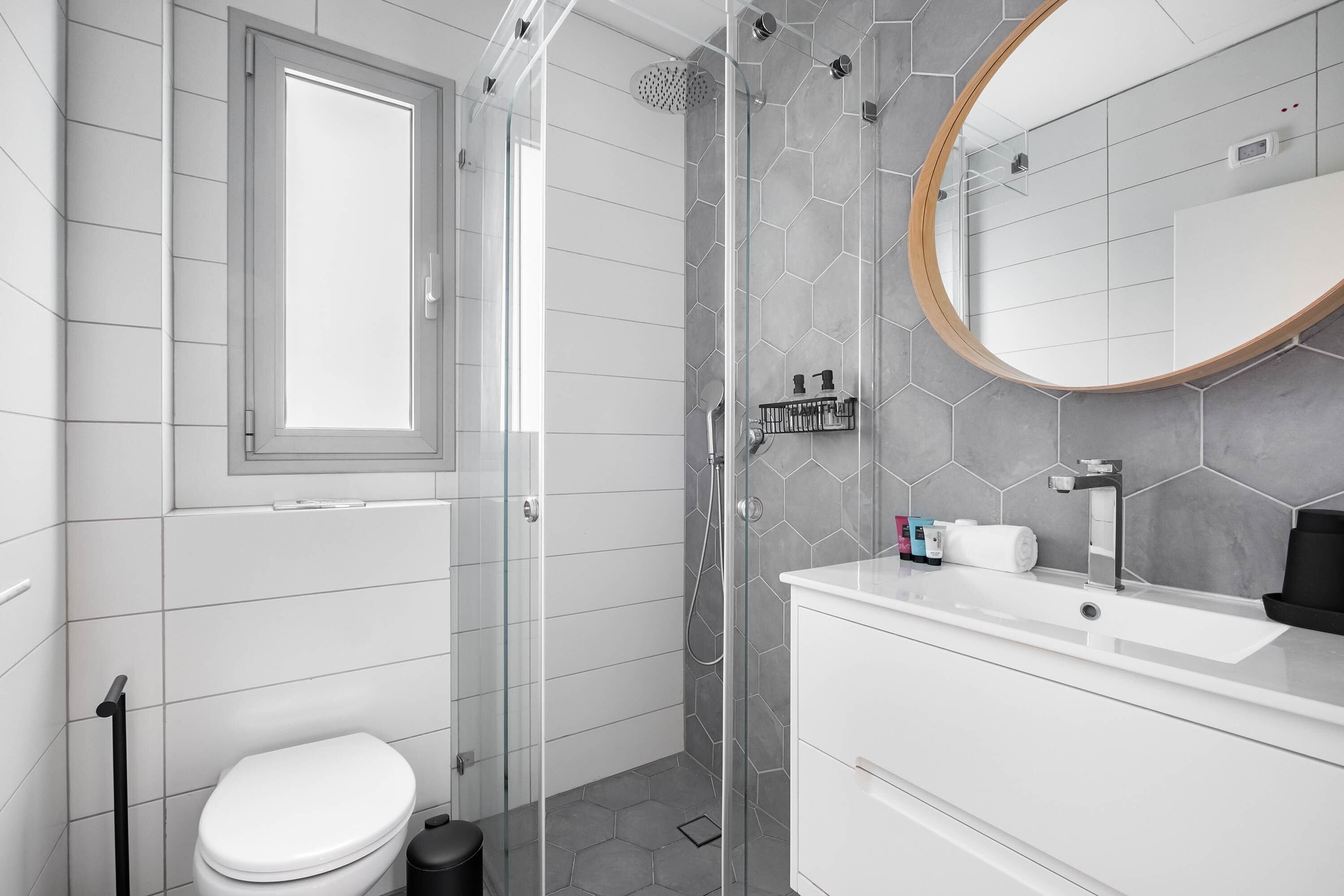 Un baño moderno con ducha, inodoro y tocador.