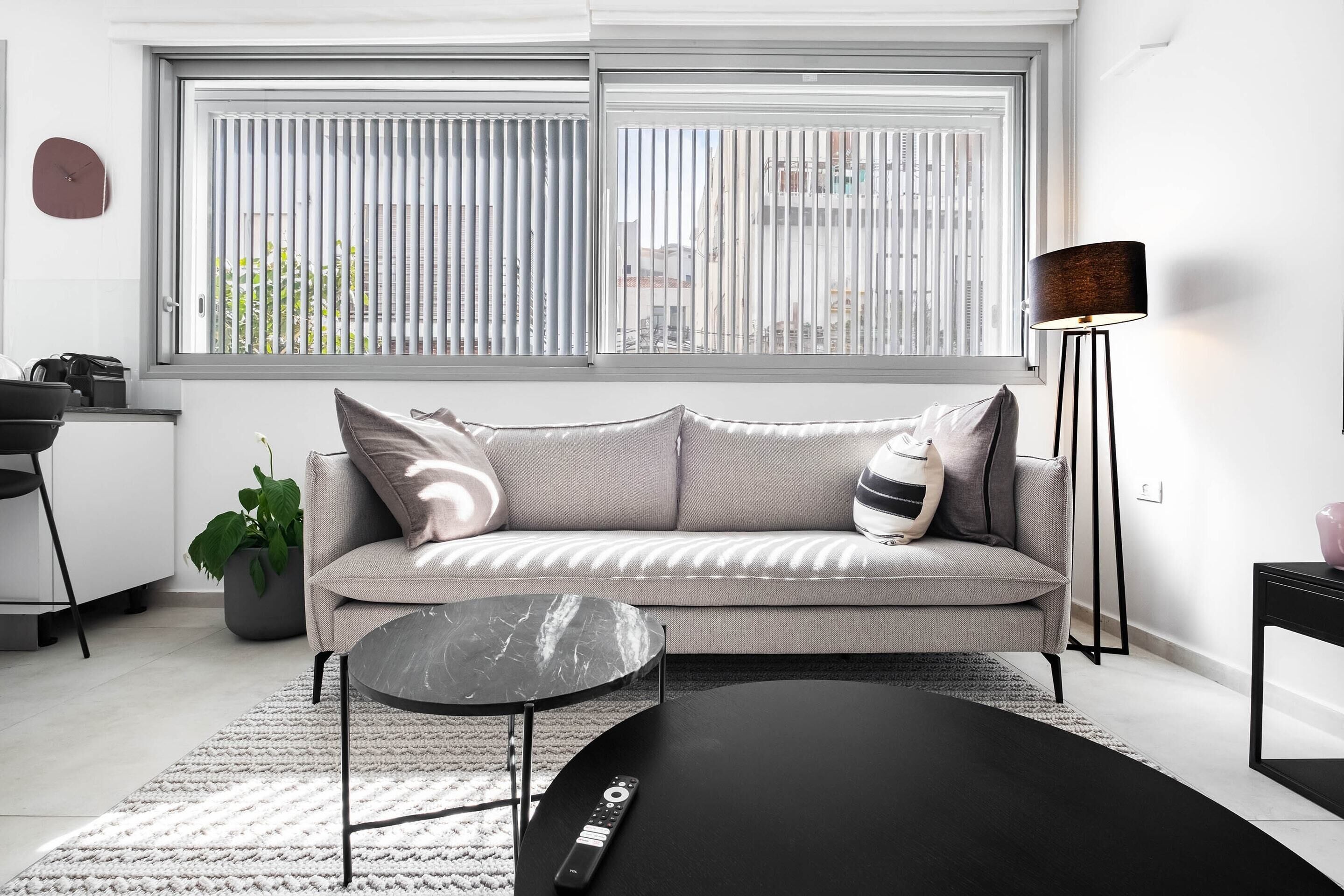 A modern living room with a sofa, a coffee table, and a floor lamp.