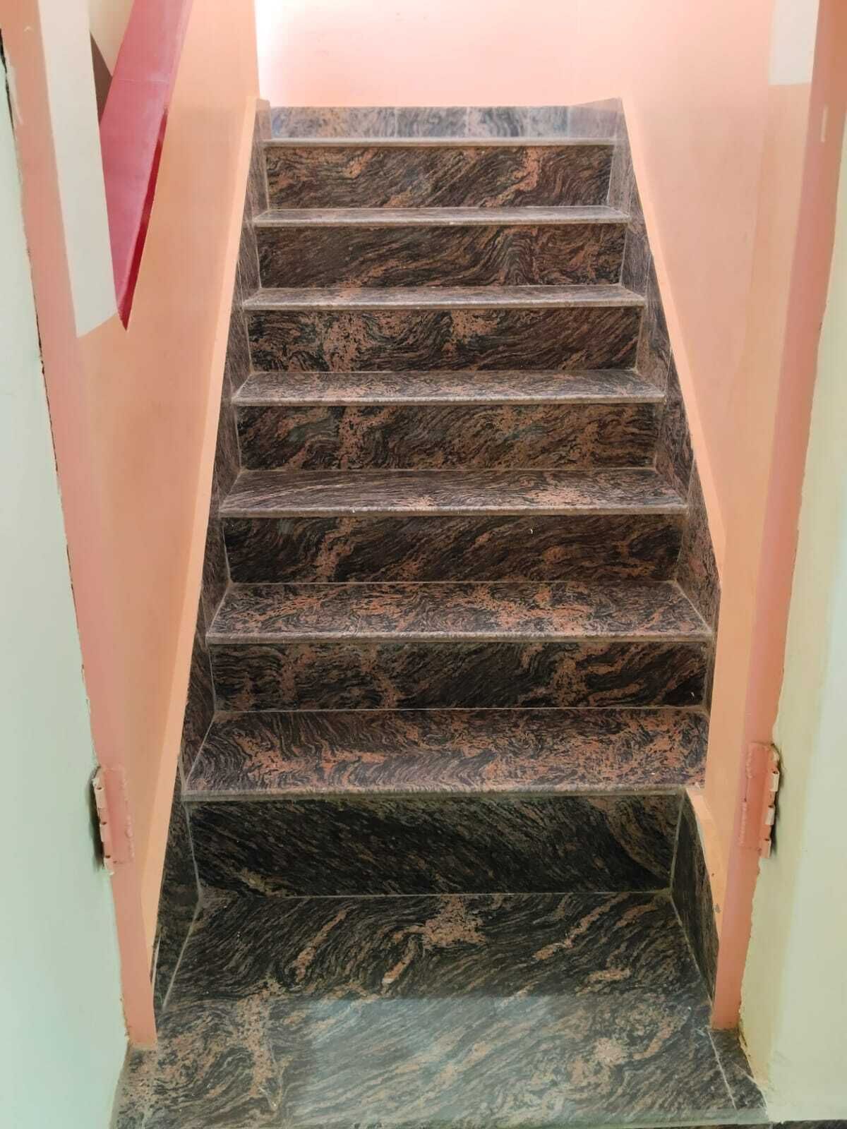 A staircase with dark, patterned steps leading to a landing.