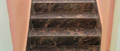 A staircase with dark, patterned steps leading to a landing.