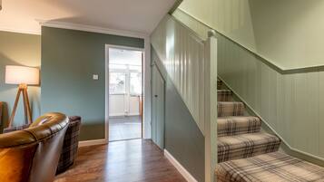 A staircase with plaid carpet leading to a door.