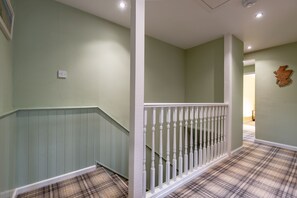 A staircase with a white railing and a plaid carpet.
