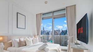 Una habitación de hotel con una cama grande, televisión y vistas a la ciudad.