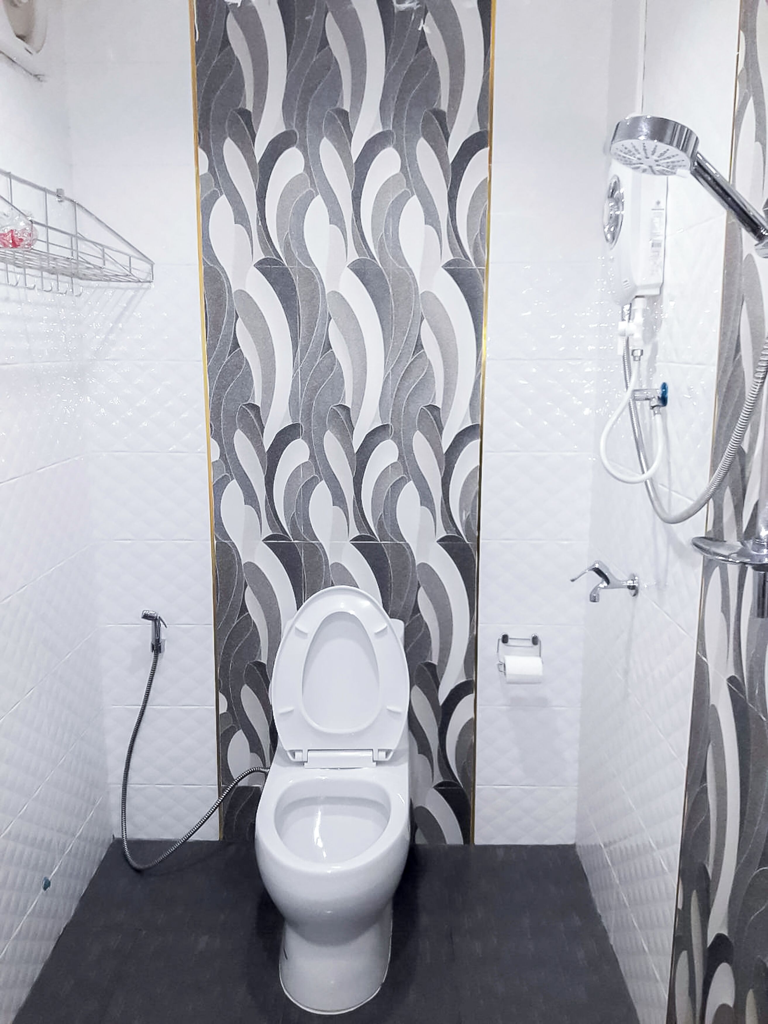 A bathroom with a toilet, a shower, and a towel rack.