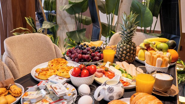 A breakfast buffet with various fruits, pastries, and beverages. - Mattis Hotel (Tirana)