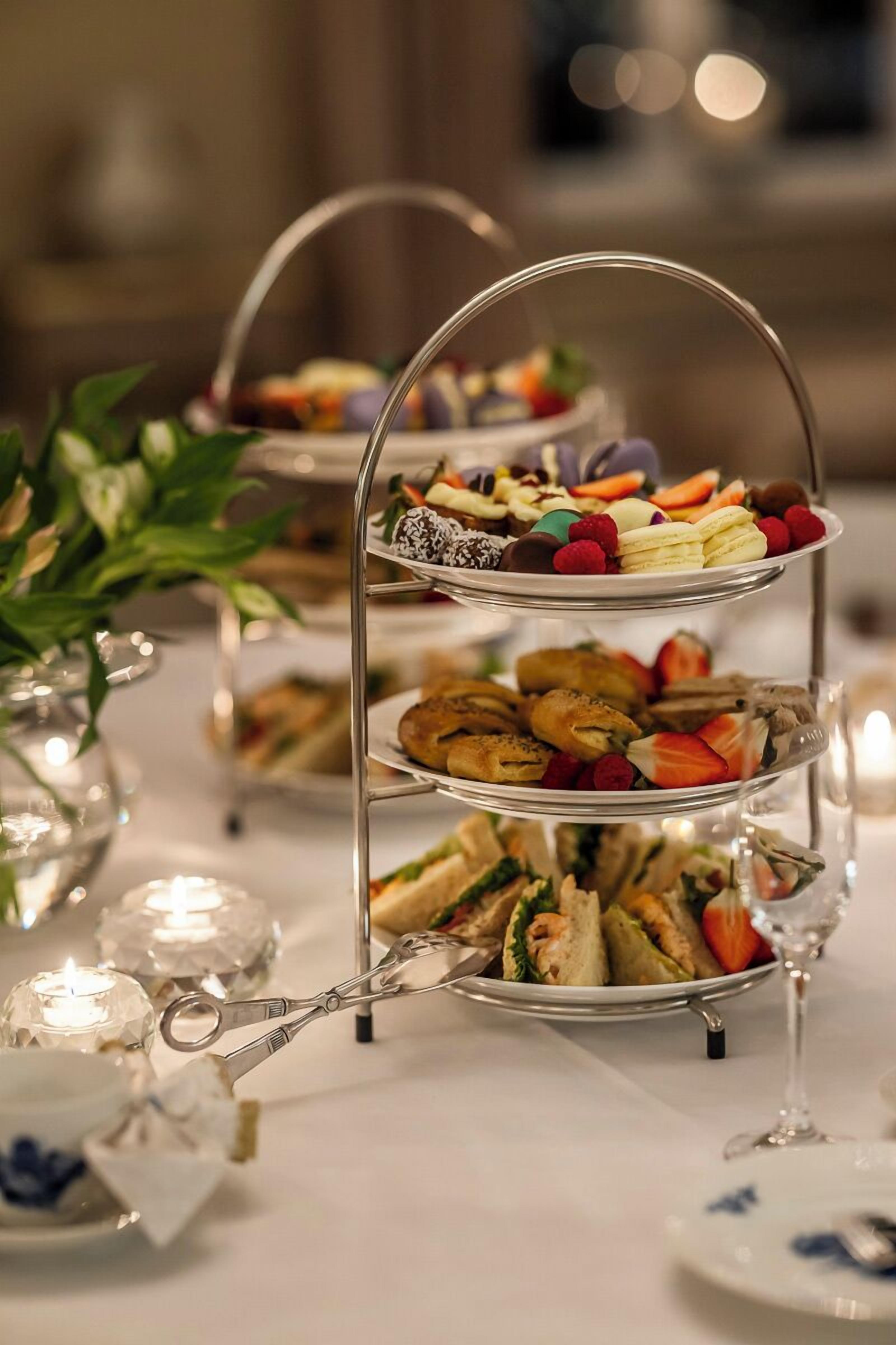 Un soporte escalonado para postres con diversos pasteles y frutas.