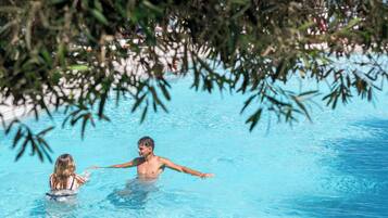 Una piscina con agua cristalina y borde de azulejos.