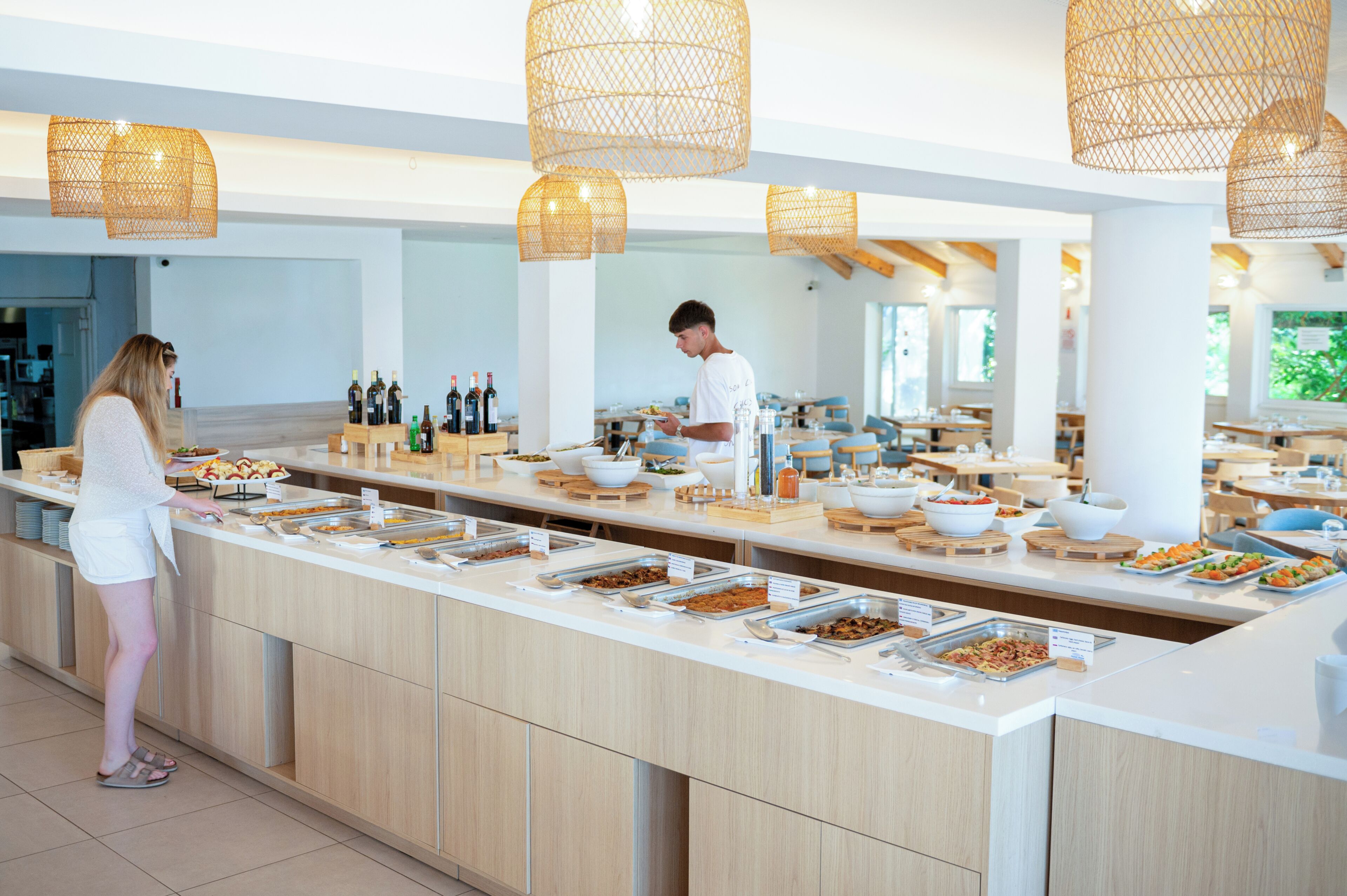 A buffet setup with multiple food stations and a person serving food.