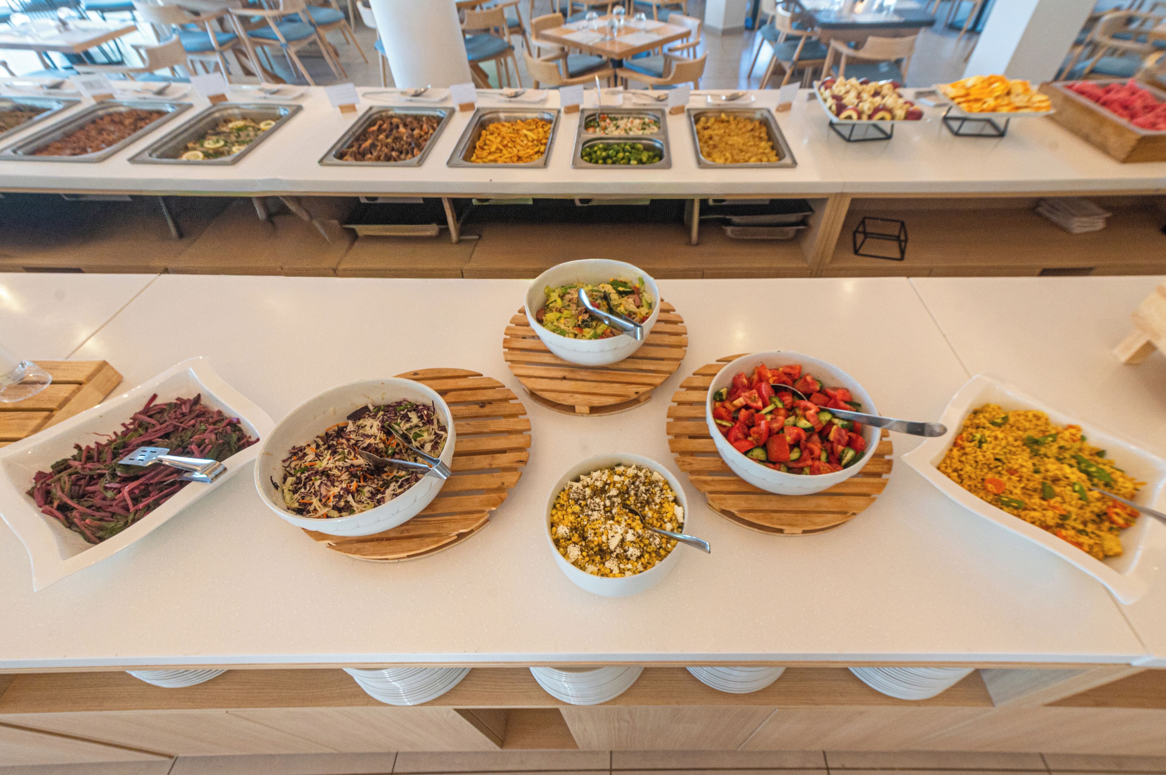 Une table de buffet proposant divers plats et des salades.