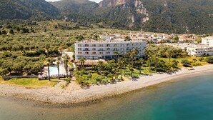 A hotel with a pool, beach, and mountains in the background. - Hotel Sissy (Kamena Vourla)