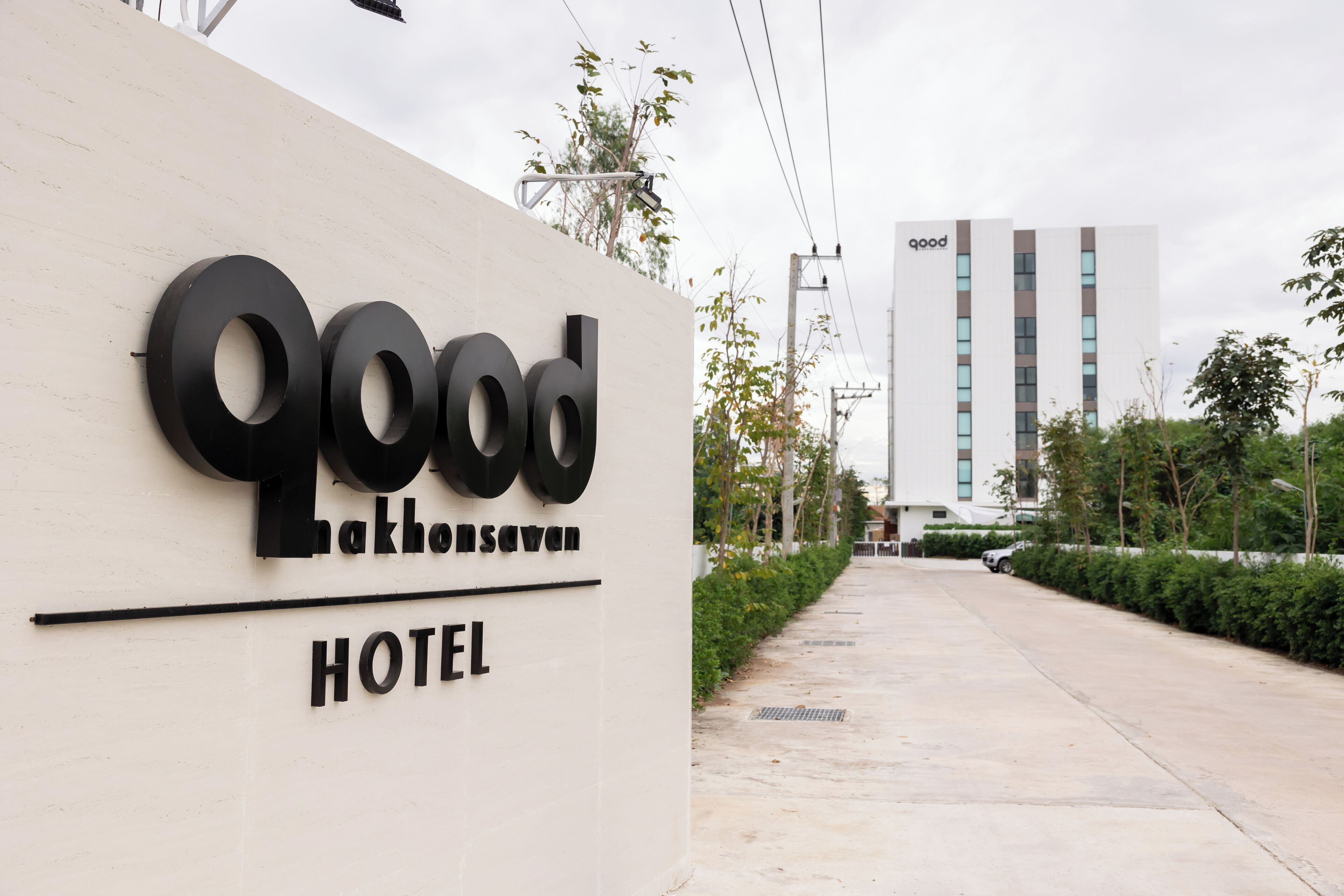 A sign for the "Good Lakensaven Hotel" with a modern building in the background.