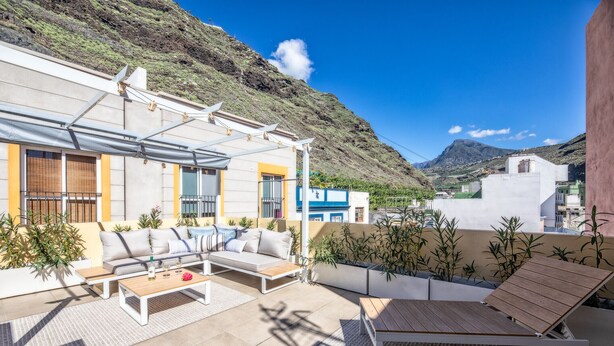 A rooftop terrace with a sofa, lounge chairs, and a pergola. - Casa El Puerto by Huskalia (Tazacorte)