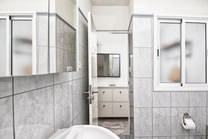 A modern bathroom with a glass shower enclosure, a white sink, and a toilet. - Casa El Puerto by Huskalia (Tazacorte)