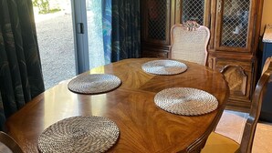 Comedor con una mesa de madera y cuatro sillas, cada una con un mantel tejido.
