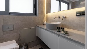A modern bathroom with a large sink, a toilet, and a trash bin. - Phaedrus Living Athens Luxury Residences Sunstone (Athens)