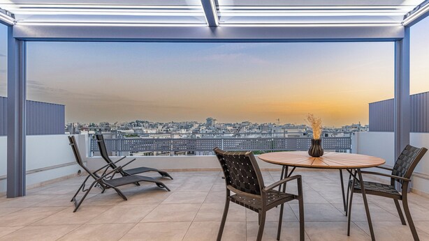 A modern balcony with a city view, a round table, and two chairs. - Phaedrus Living Athens Luxury Residences Sunstone (Athens)