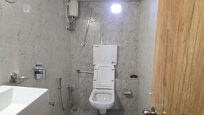 A bathroom with a toilet, bidet, and a sink. - Classy Ac Dormitory (Mumbai)