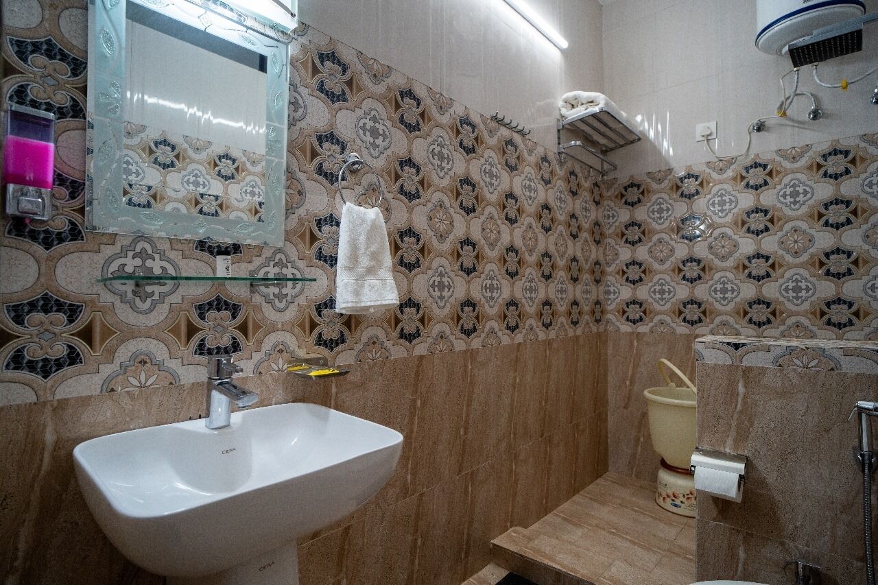 Ein Badezimmer mit Waschbecken, Spiegel und Mustertapeten.