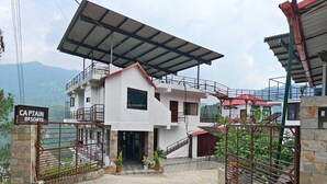 A modern two-story building with a covered entrance and a sign reading "Captain Resorts". - Captain Resort (Kasauli)