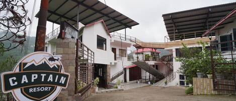 Un resort llamado "Captain", con un letrero, un edificio con escalera y vistas del entorno.