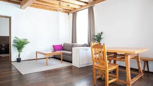 A modern living room with a wooden dining table, a sofa, and a coffee table.