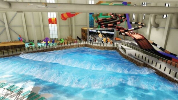 An indoor water park with a wave pool, a water slide, and a viewing area with spectators. - The Cozy Modern Cabin – Ski & Relax (Tobyhanna)