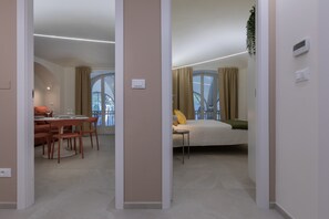 A modern apartment with a dining area, a bedroom, and a balcony with a view.