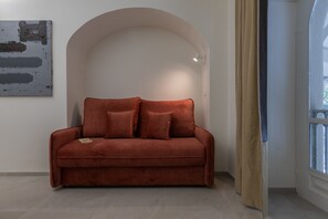 A red sofa in a room with a white wall and a large window. - Ai Portici di Susa - Classy by Wonderful Italy (Turin)