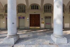 Ein Gebäudeeingang mit einer großen Holztür, flankiert von zwei Säulen aus Stein, und einem Schild, das ein Restaurant anzeigt.